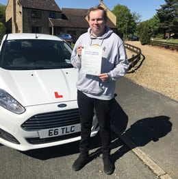 Successful student hoding their driving test certificate